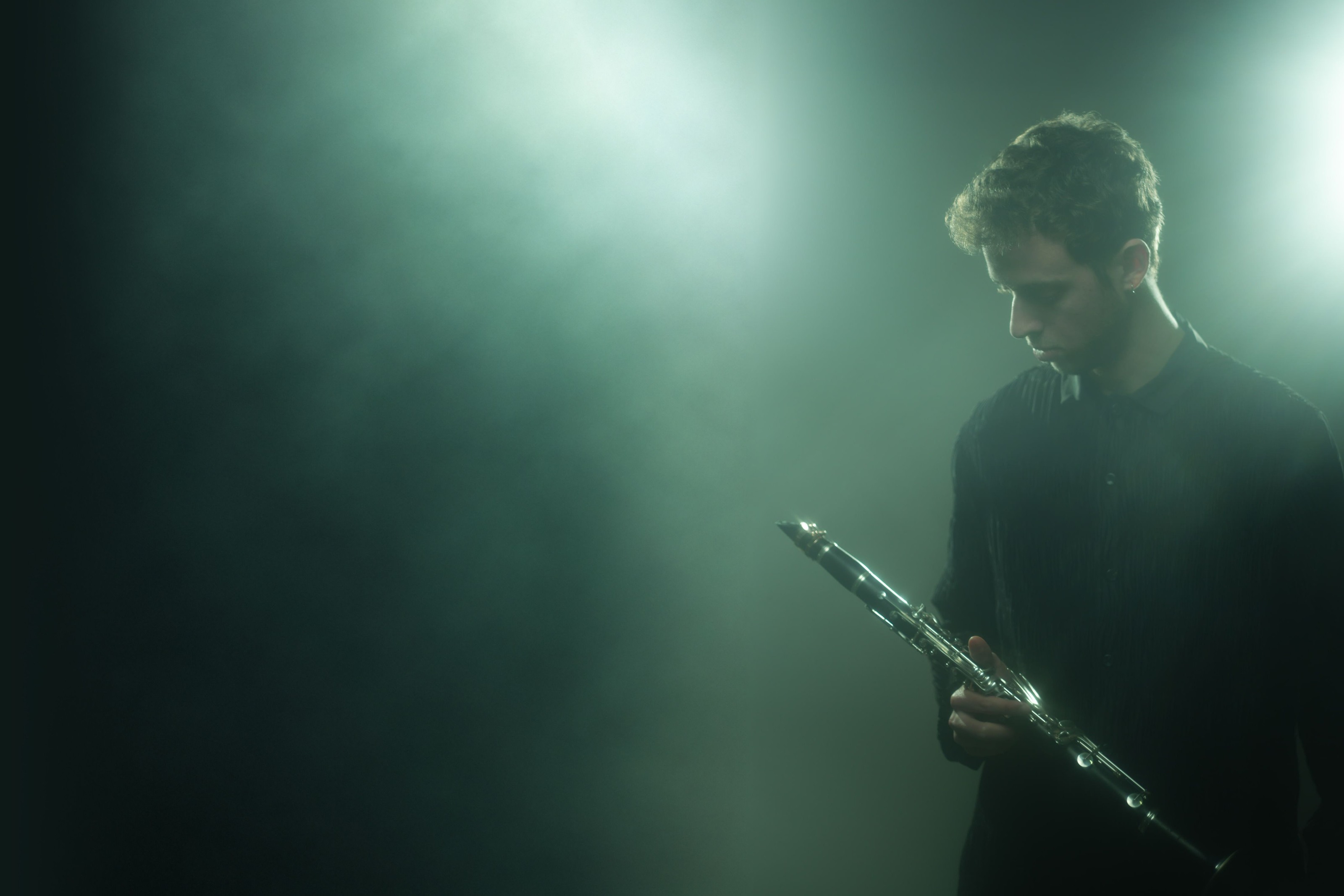 Jonathan Leibovitz in teal haze, looking down at his clarinet