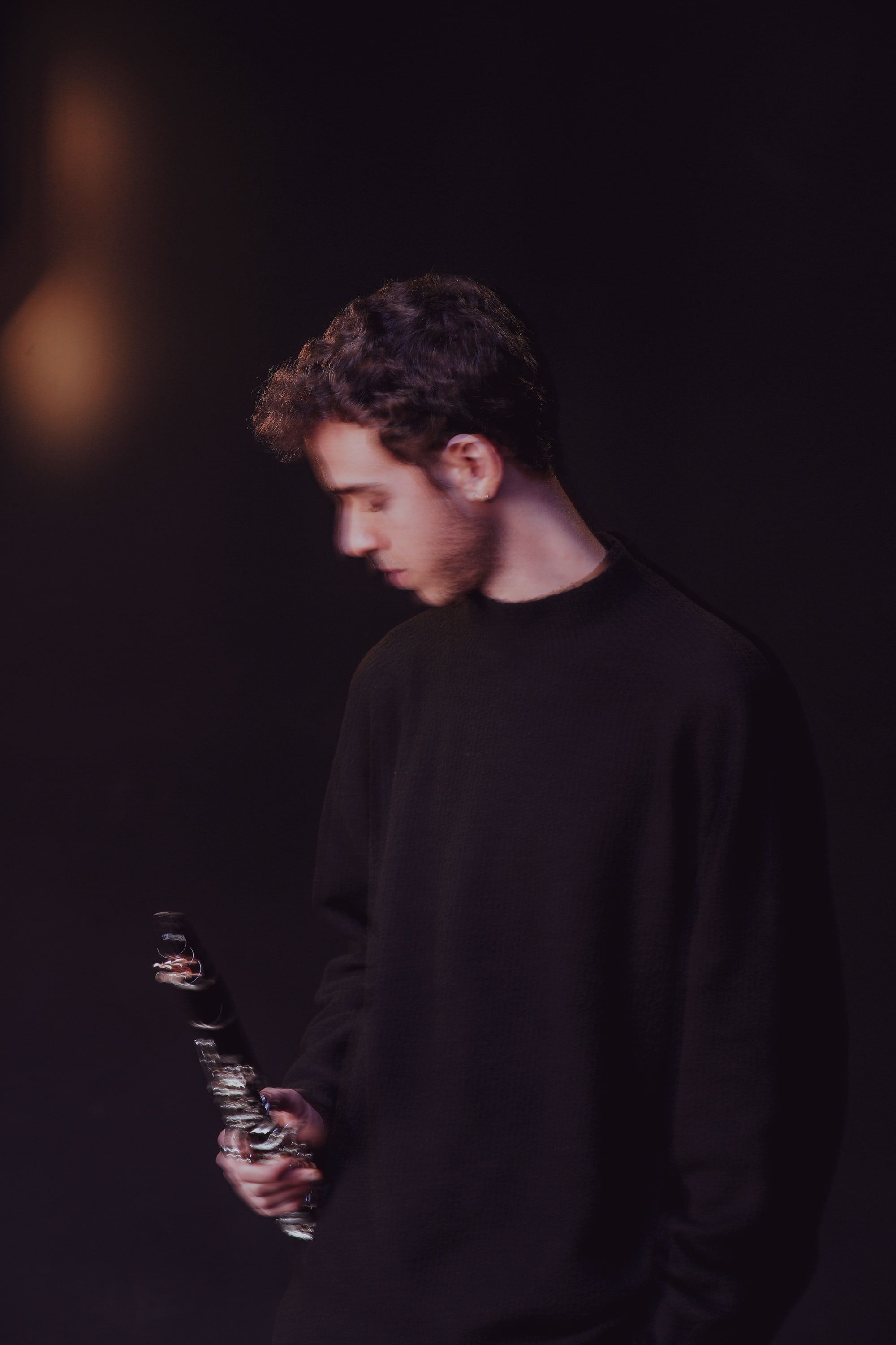 Jonathan Leibovitz in violet light, his head bowed towards his clarinet
