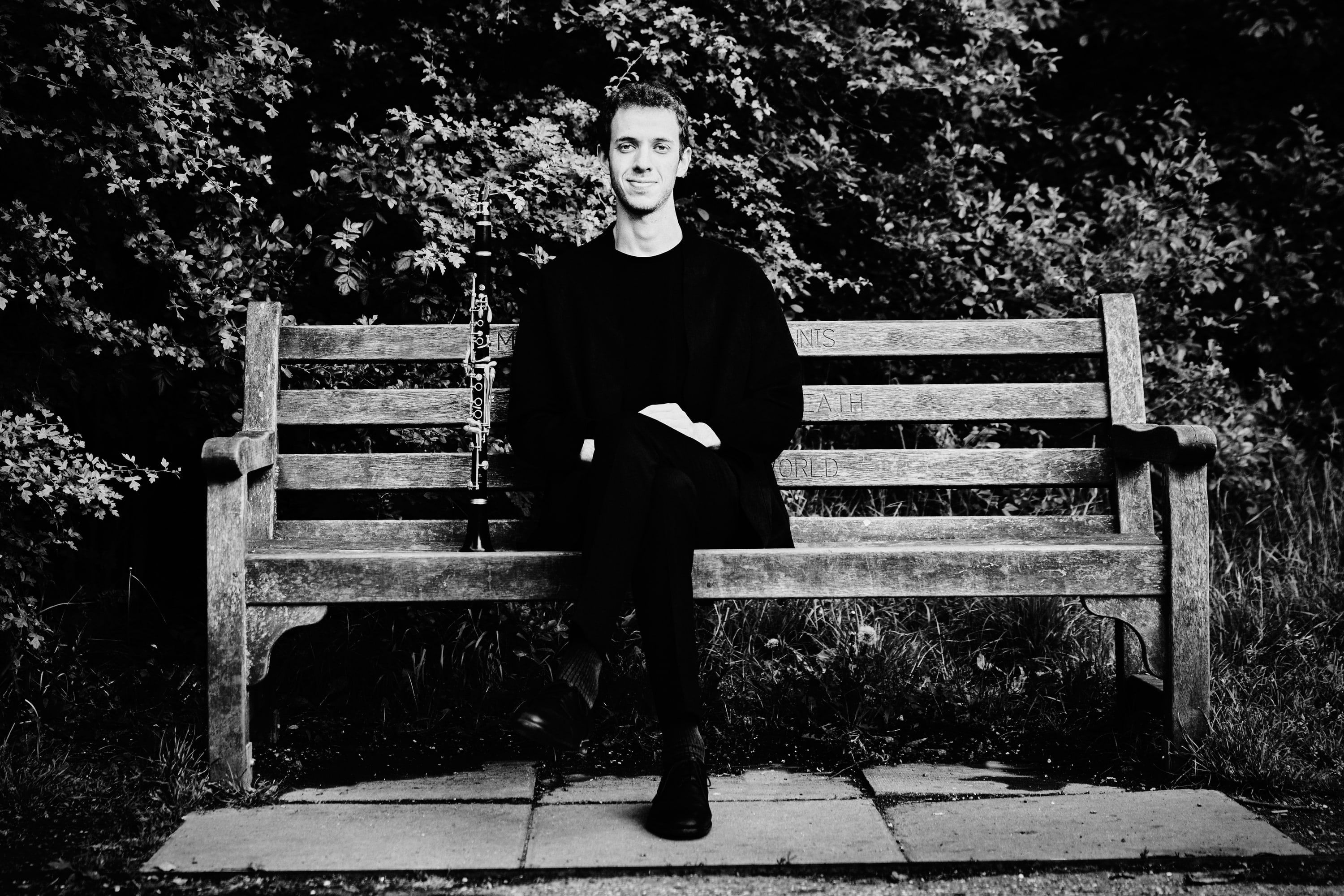 Black-and-white photograph of Jonathan Leibovitz seated on a park bench