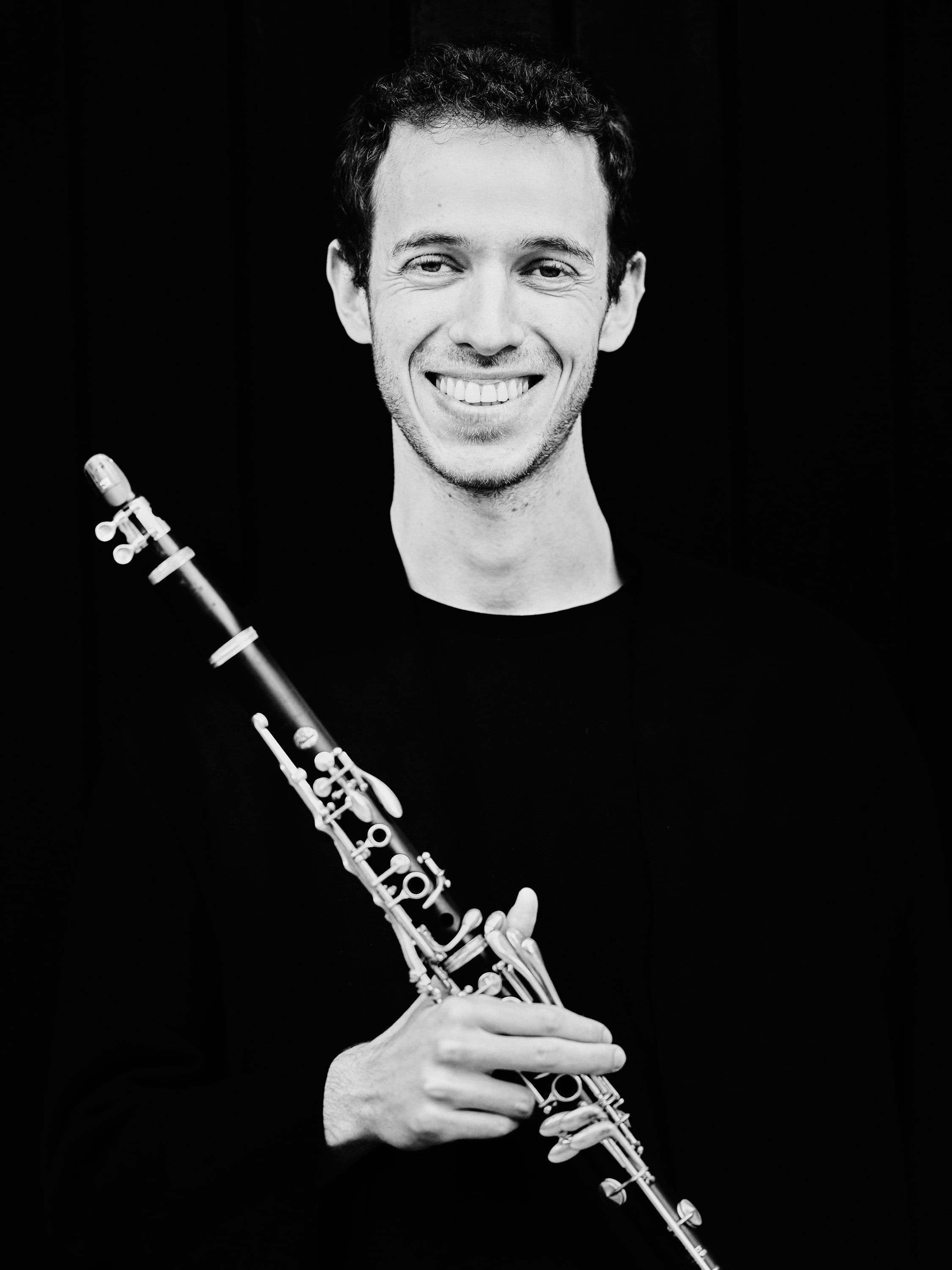 Black-and-white portrait of Jonathan Leibovitz smiling, holding his clarinet