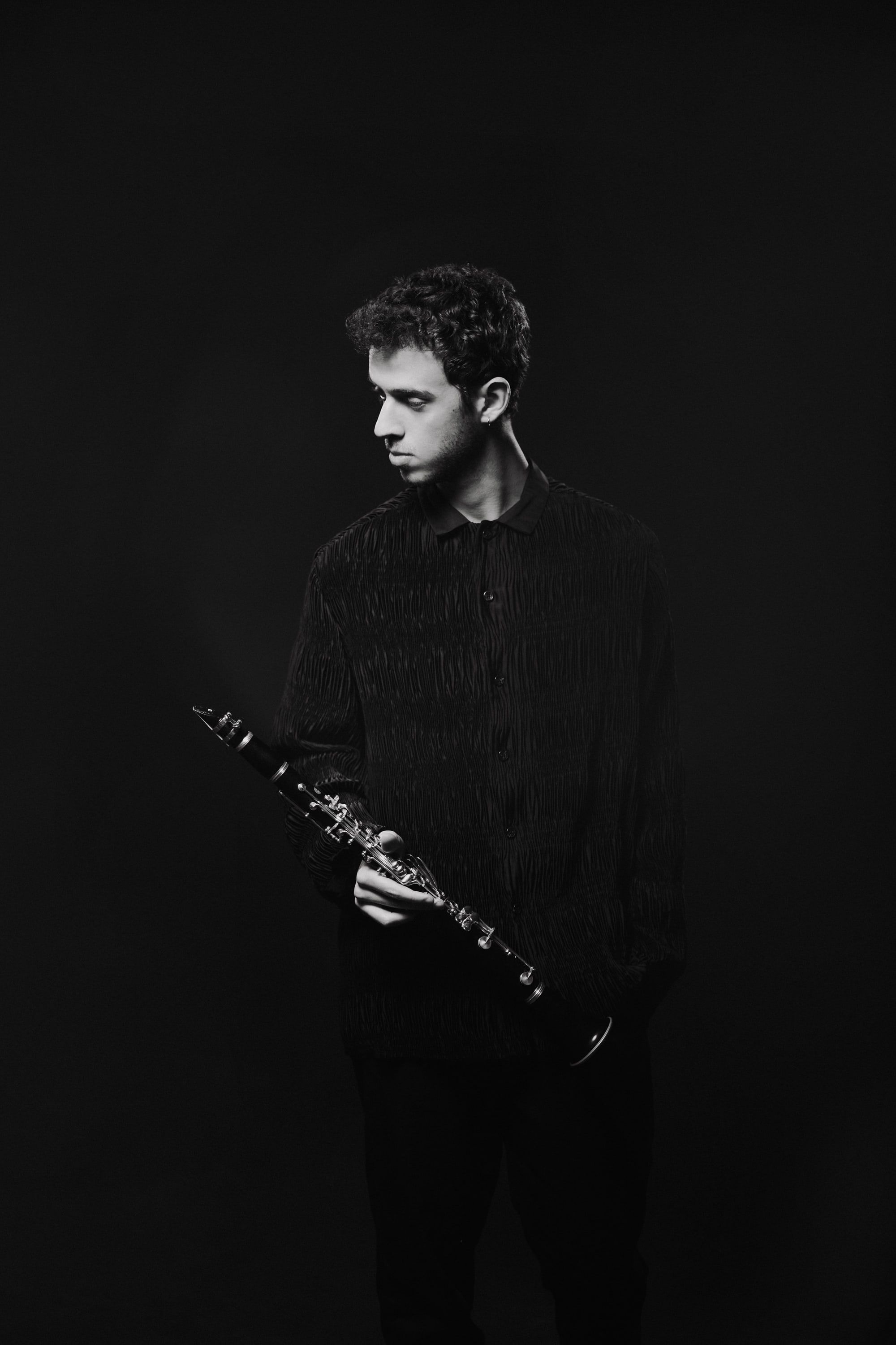 Jonathan Leibovitz in a dark studio, clarinet in hand